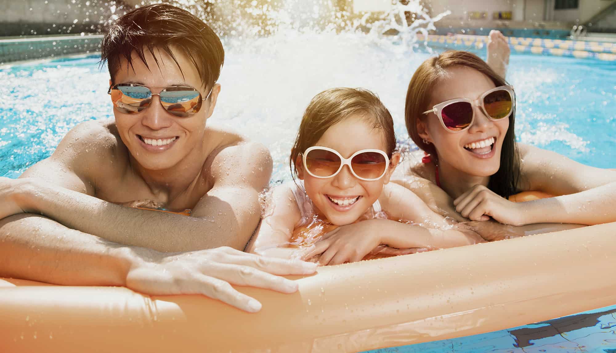 Happy family playing in swimming pool